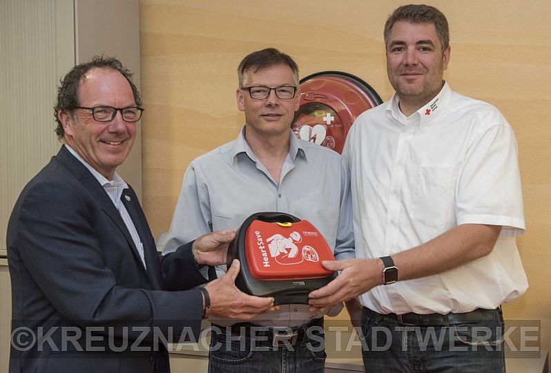 Auf dem Foto von links nach rechts: Klaus-Dieter Dreesbach, Christof Pronobis (Ersthelfer Kreuznacher Stadtwerke) und Bastian Wolff mit dem Defibrillator im Kundenzentrum Energie Eck
